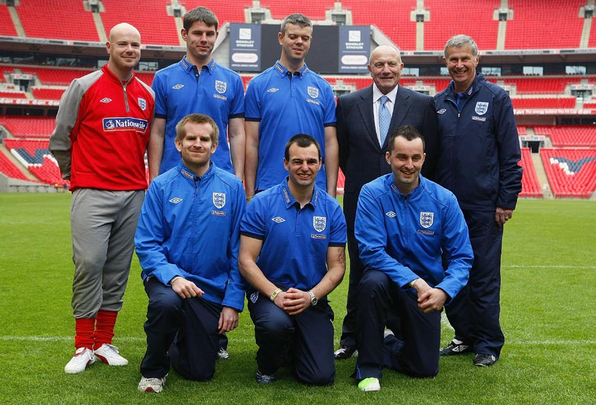 The England Blind squad line-up alongside George Cohen on the Wembley pitch.